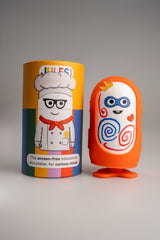 Jules in the orange outfit with drawings, next to a Jules gift box