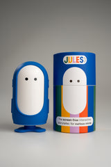 Jules in the blue outfit next to its Jules gift box